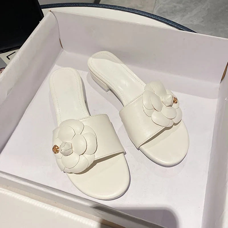 Sandales femme avec fleur de camélia, design élégant, chaussures d’été décontractées avec talons bas, ornements métalliques, idéales pour un style chic et tendance.