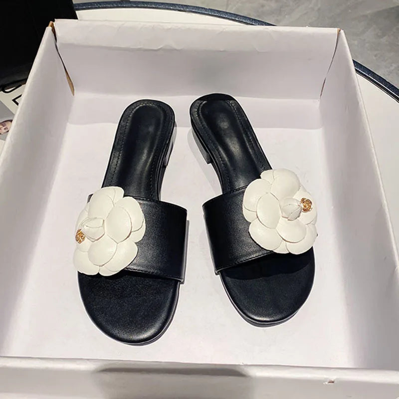 Sandales femme avec fleur de camélia, design élégant, chaussures d’été décontractées avec talons bas, ornements métalliques, idéales pour un style chic et tendance.