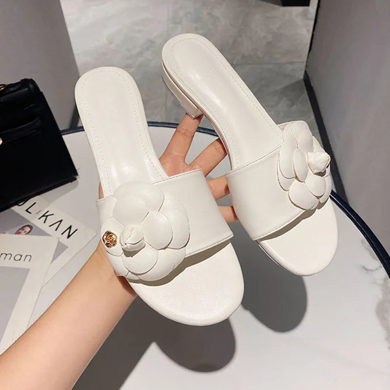 Sandales femme avec fleur de camélia, design élégant, chaussures d’été décontractées avec talons bas, ornements métalliques, idéales pour un style chic et tendance.